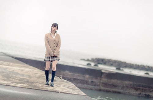 埠頭を歩く女子高生の写真