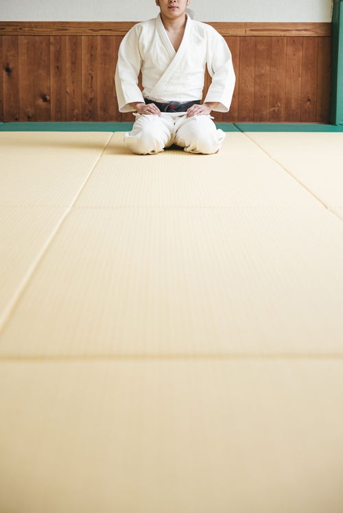 畳の上で正座する柔道家の写真