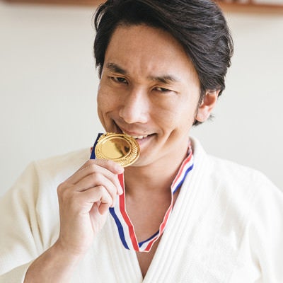 金メダルを噛む選手の写真