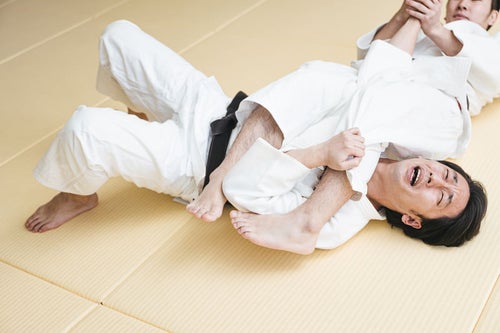 腕ひしぎ十字固めに悶える柔道選手の写真