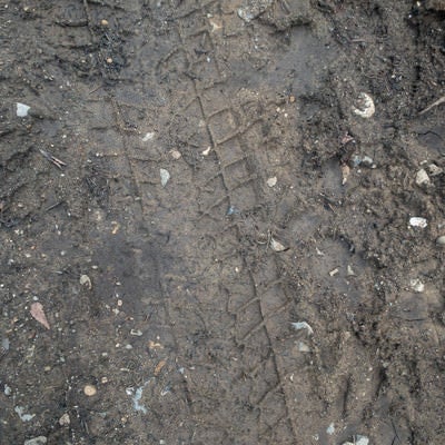 濡れた地面に残るタイヤ痕のテクスチャーの写真