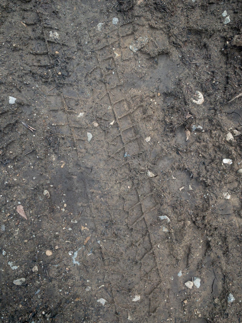 「濡れた地面に残るタイヤ痕のテクスチャー」の写真