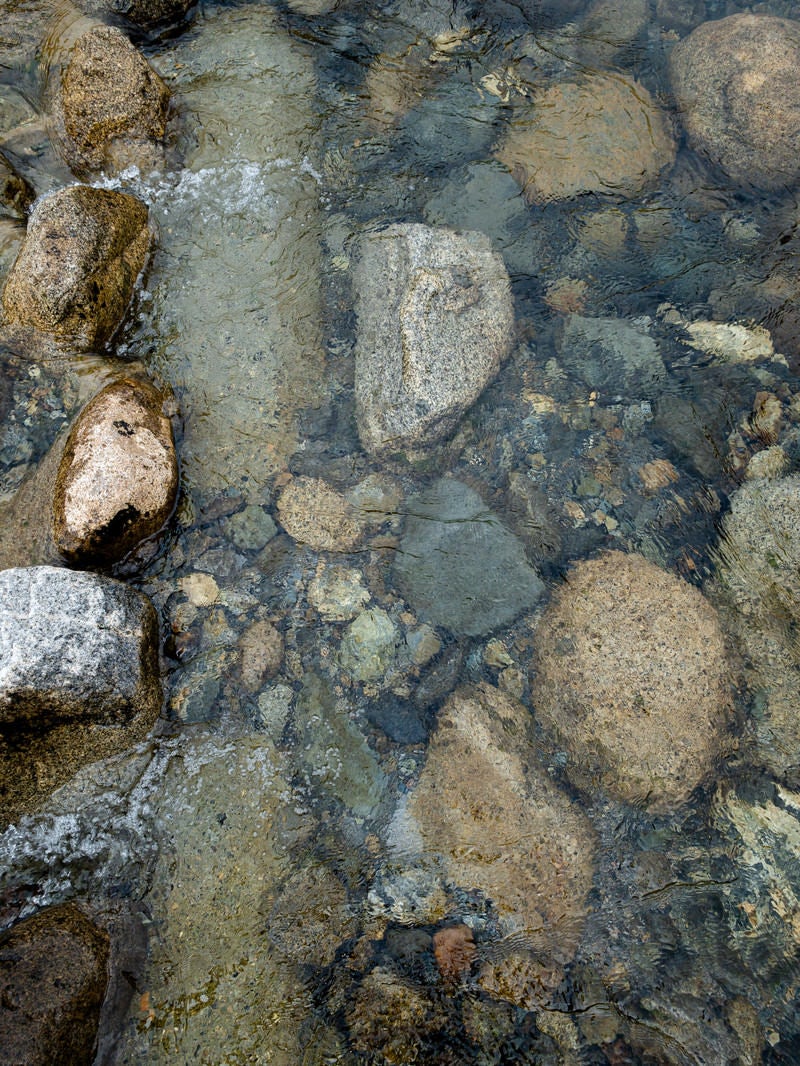 「底の石ころが透き通る水面」の写真
