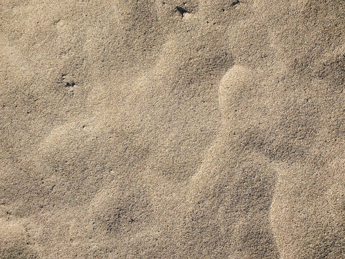 砂の上にうっすらと残る風紋（テクスチャー）の写真