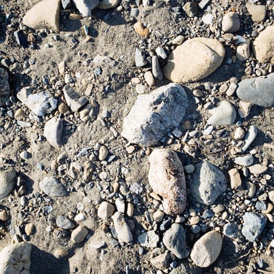 砂地に残る大中小の石（テクスチャー）の写真