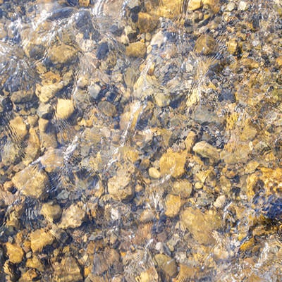 水底の小石と水の流れ（テクスチャー）の写真