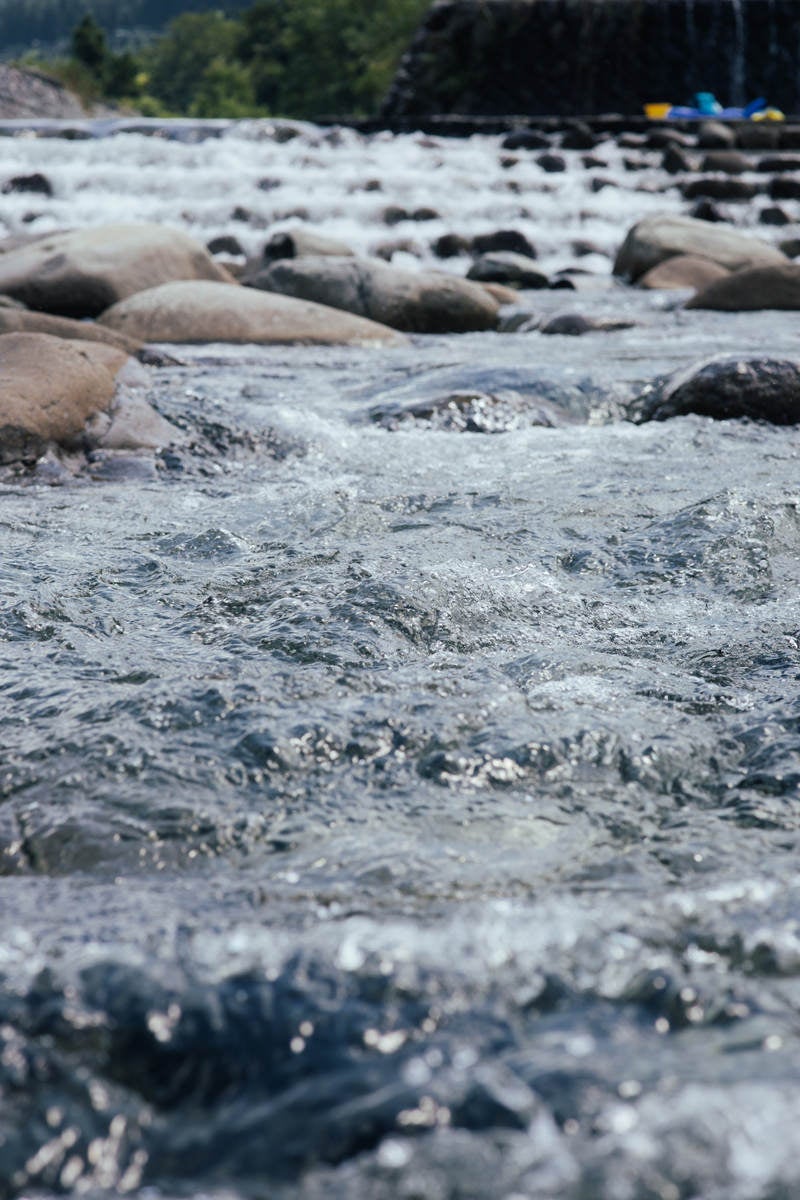 「砂防ダムから流れ込む川の水面（新潟県南魚沼郡塩沢町）」の写真