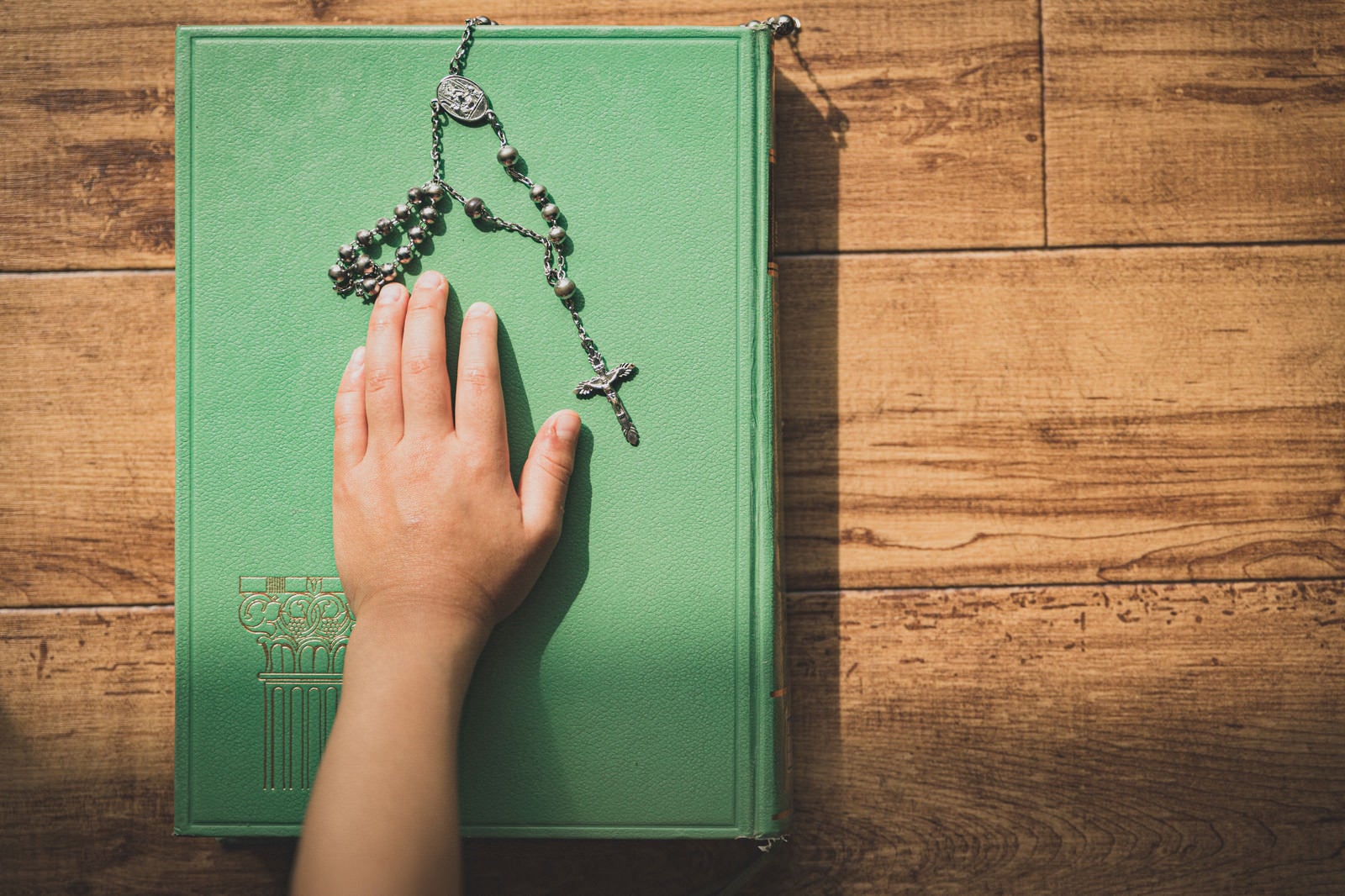 「聖書に手を置き誓う子供の手」の写真