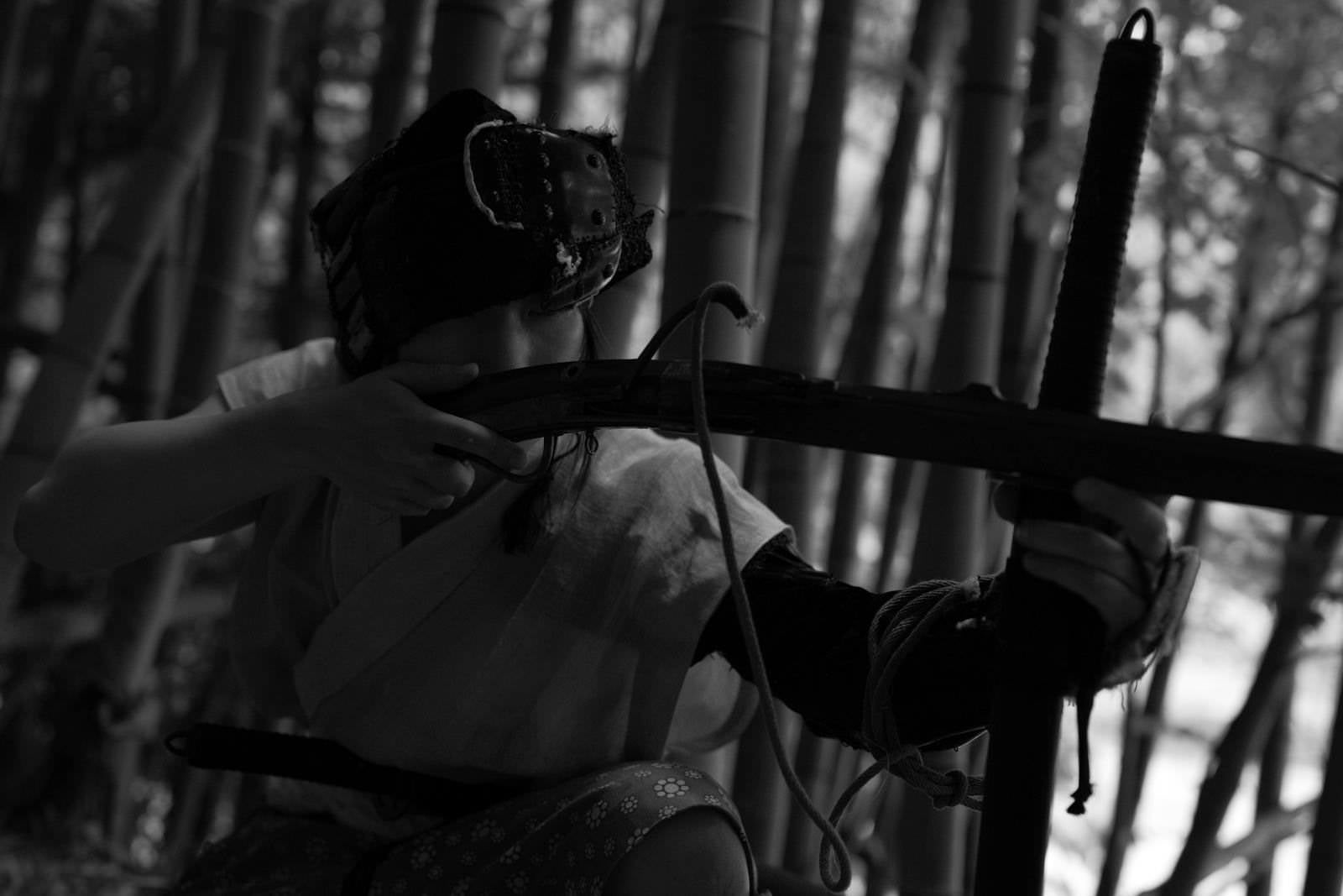「竹林の陰から火縄銃で追手を狙う山賊」の写真［モデル：まーこ］