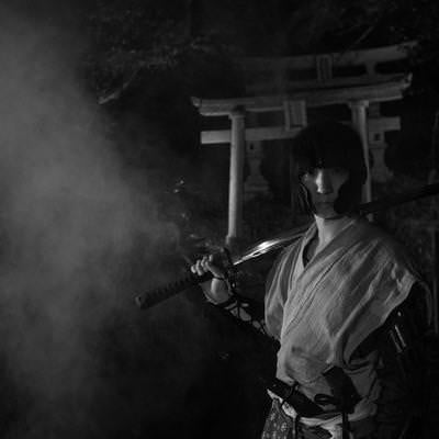 煙を纏う日本刀を担ぐ侍の写真