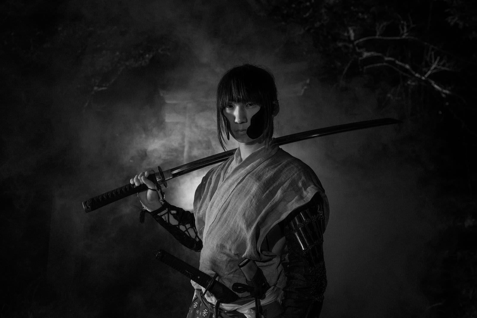 「煙の中から登場する刀を担ぐ武士」の写真［モデル：まーこ］