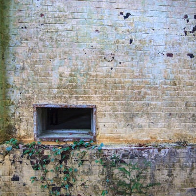廃墟の壁と通気口の写真