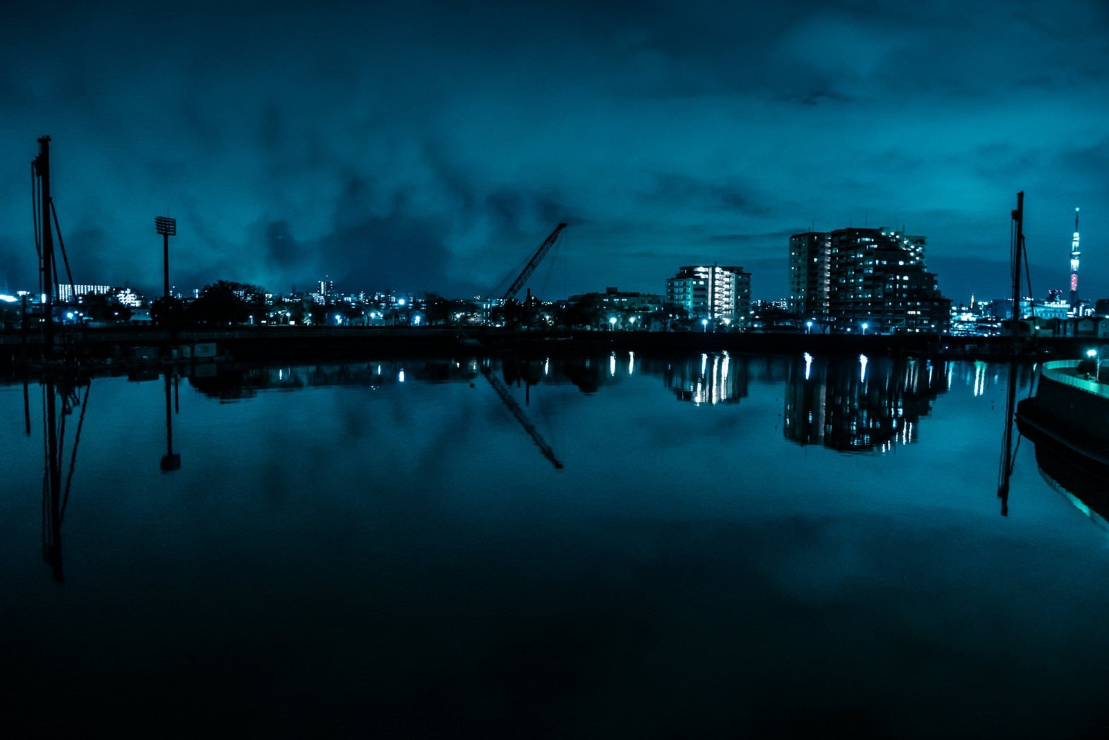 「湖面に映る街並みとクレーン（夜景）」の写真