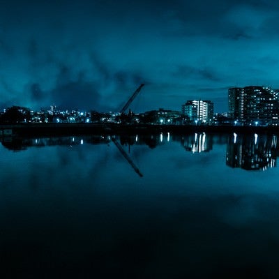 湖面に映る街並みとクレーン（夜景）の写真