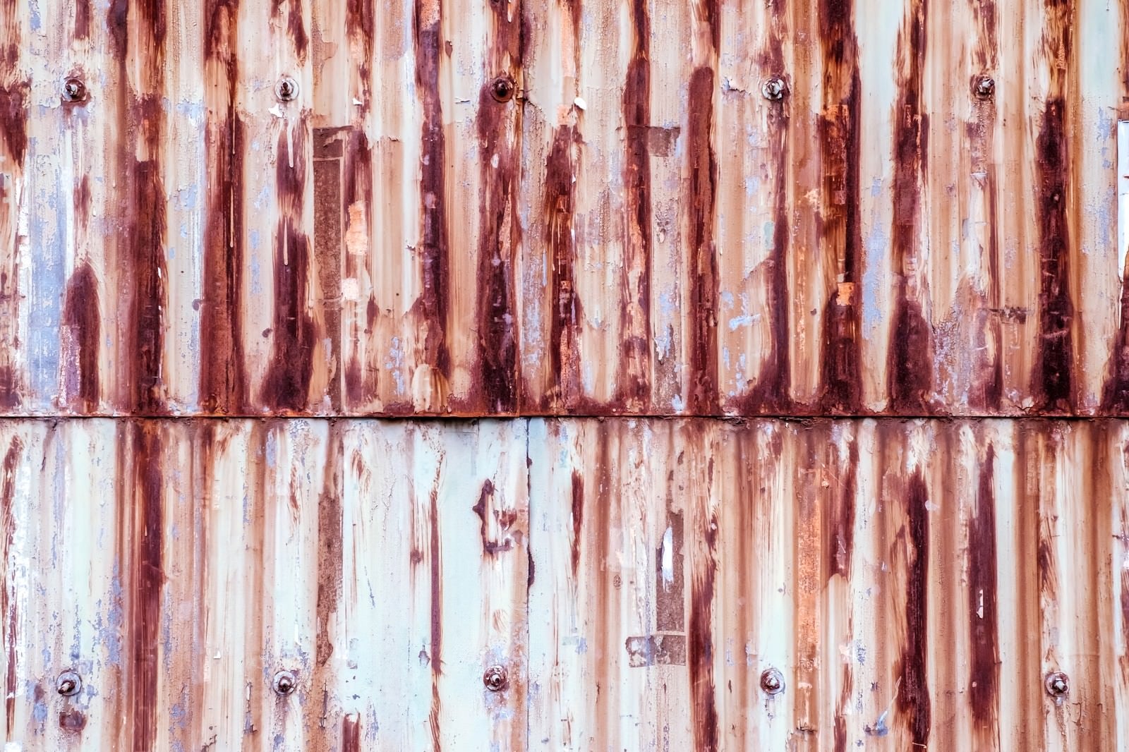 「塗装が剝がれて錆が目立つトタンの壁（テクスチャー）」の写真