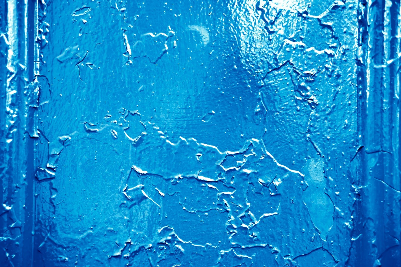 「錆びた壁に上から青いペンキを塗る」の写真