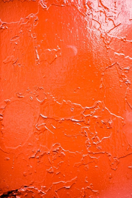錆びでひび割れた赤い壁の写真