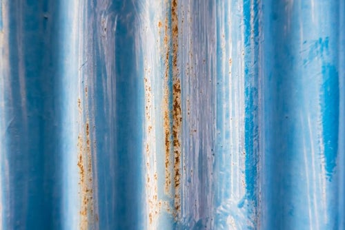 青い塗装と錆びたトタンのテクスチャーの写真