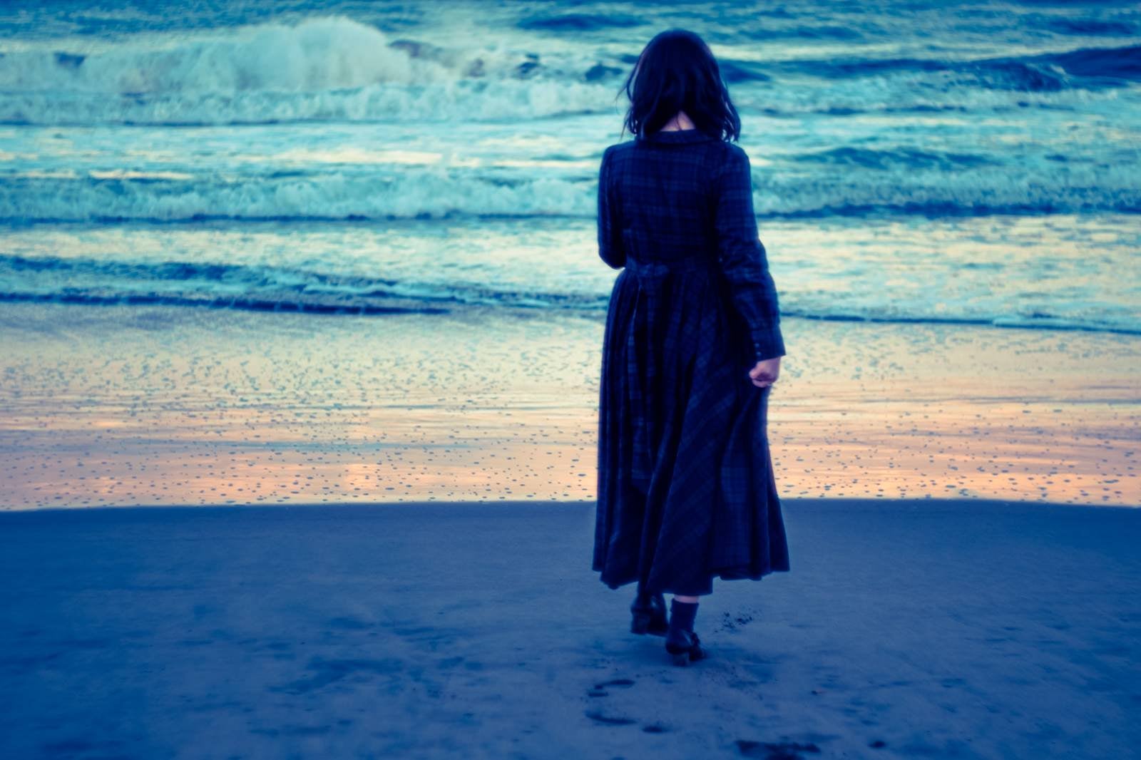 「波打ち際、寂しげな女性」の写真