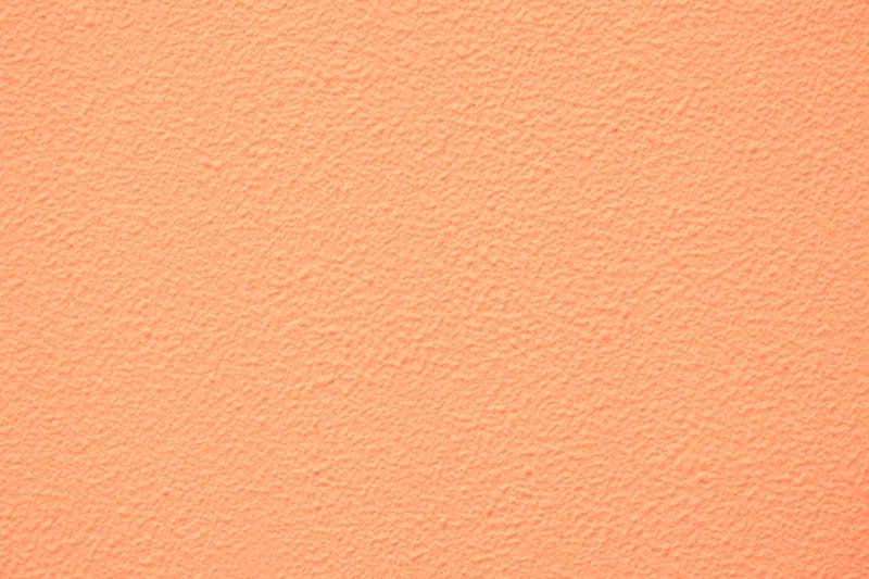 淡いオレンジ色に塗装した外壁（テクスチャー）の写真