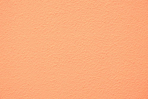 淡いオレンジ色に塗装した外壁（テクスチャー）の写真