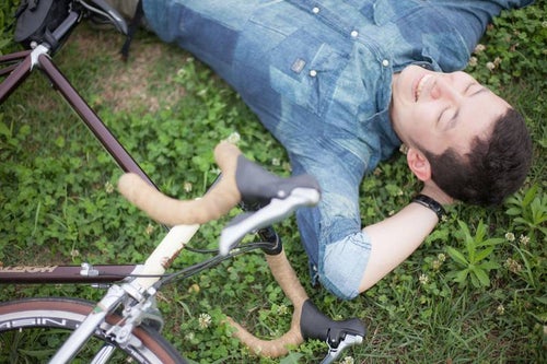 デッドヒートを避け休憩する自転車男子の写真