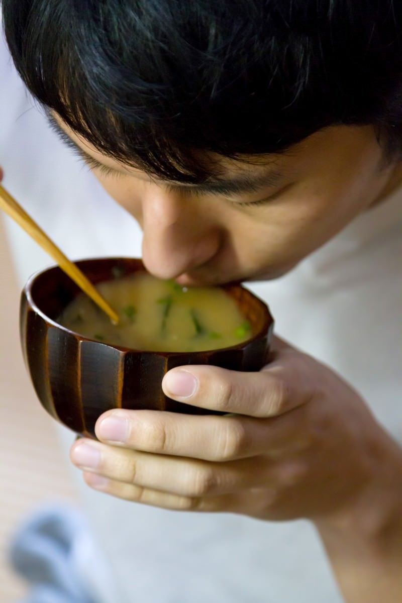 「味噌汁をすする男性」の写真［モデル：大川竜弥］