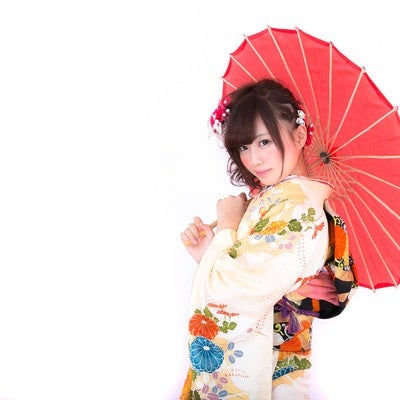 和傘を差し微笑む振袖の女性の写真