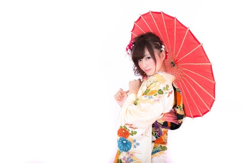 和傘を差し微笑む振袖の女性の写真