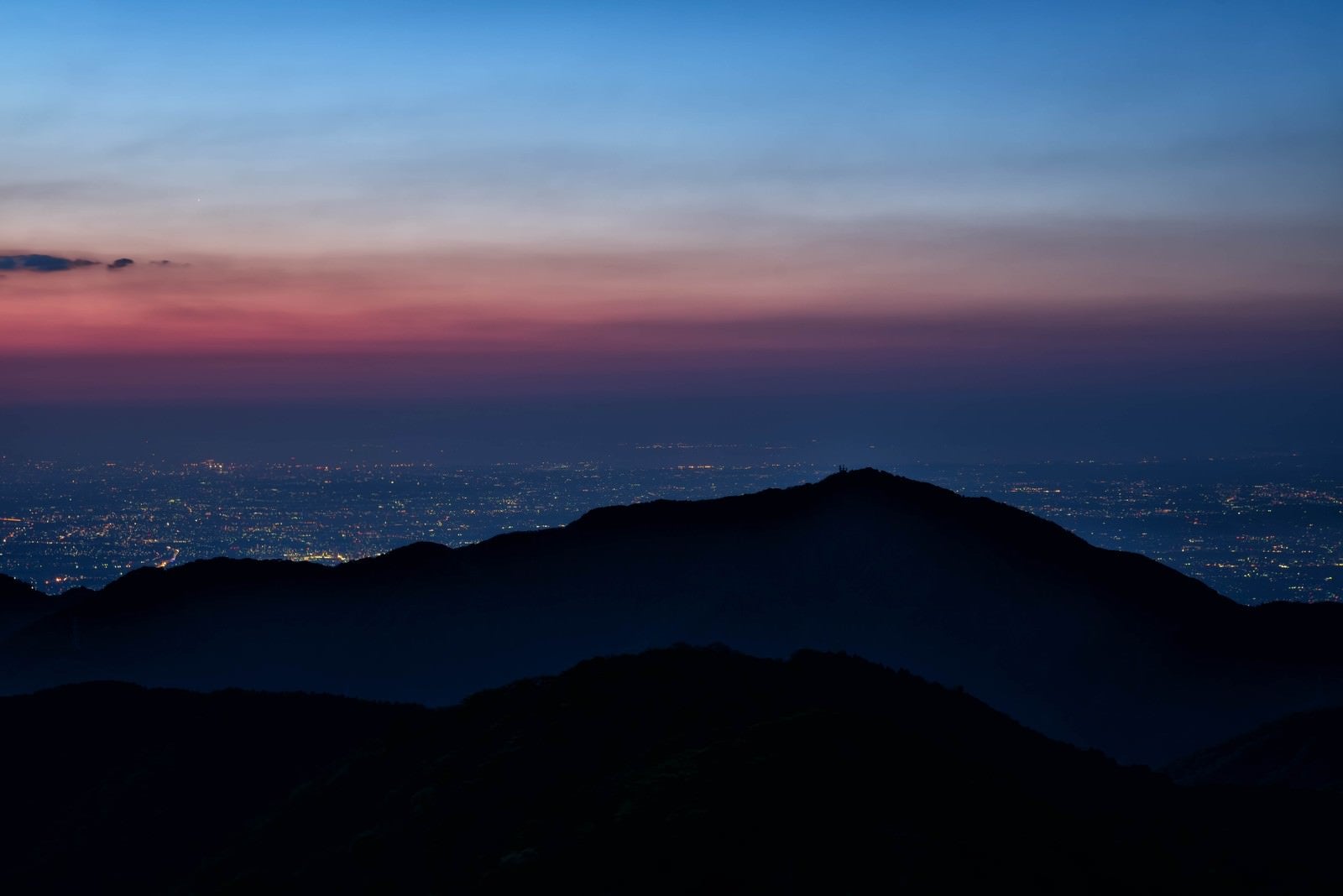 「大山のシルエットと眼下に広がる街の夜景」の写真