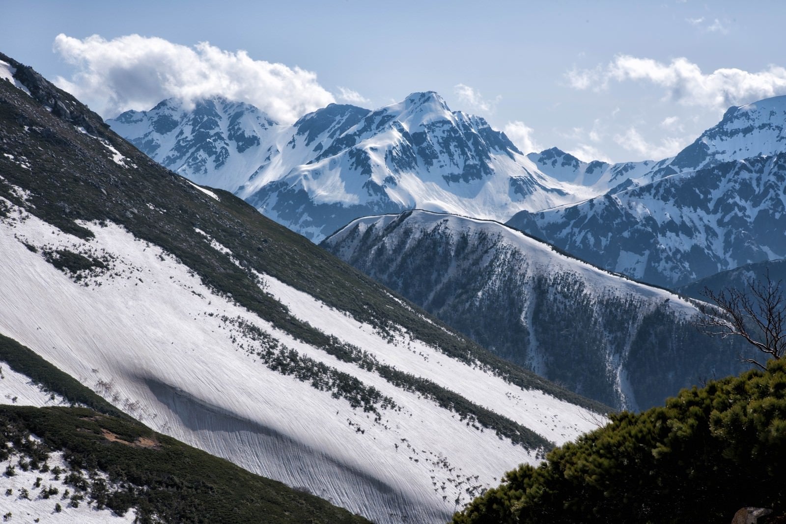 「常念山脈から望む沸き立つ雲と北穂高岳」の写真