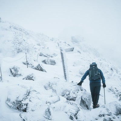 冬山の標識と登山者の写真