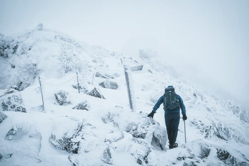 冬山の標識と登山者の写真