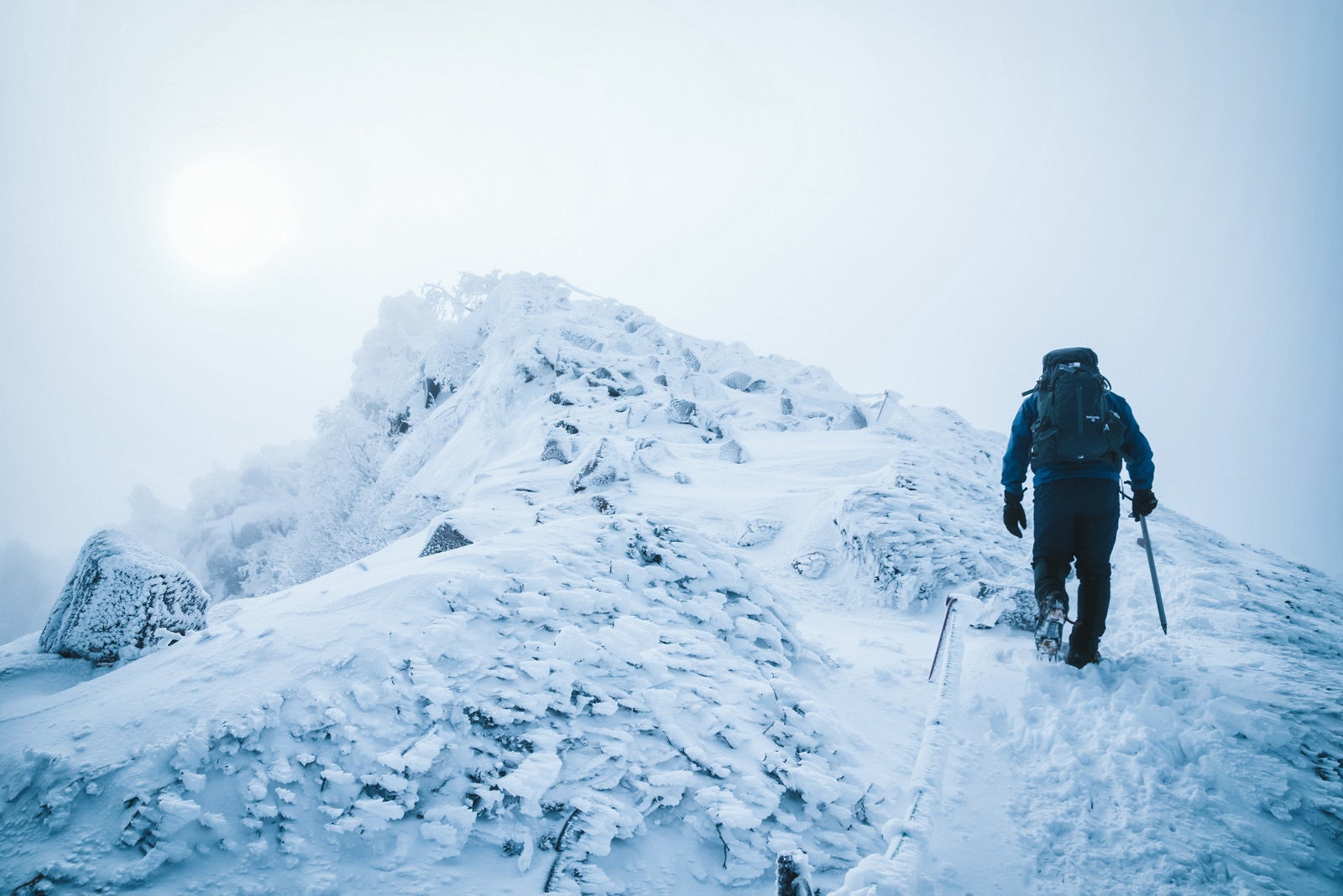「厳冬期の天狗岳の頂上を目指す登山者」の写真