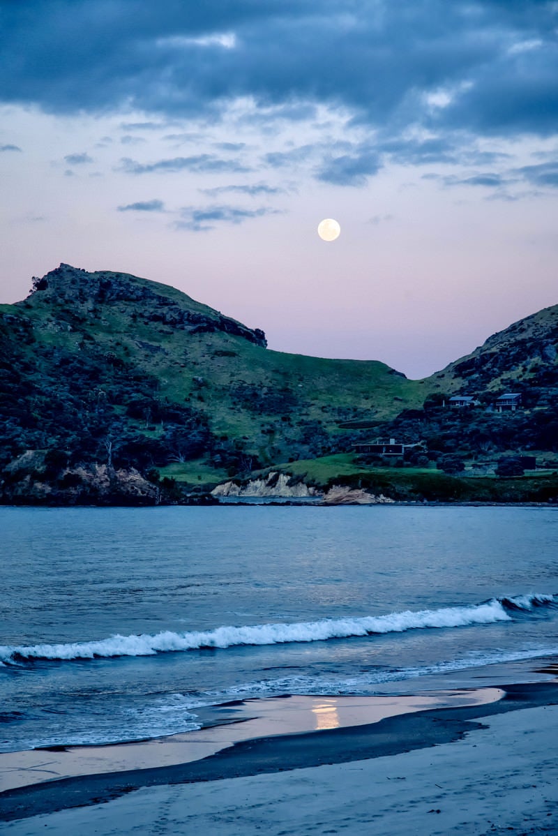 「グレートバリア島の浜辺に打ち寄せる波と満月（ニュージーランド）」の写真