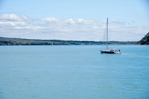 ハウラキ湾に浮かぶ帆を立てていないヨット（ニュージーランド）の写真