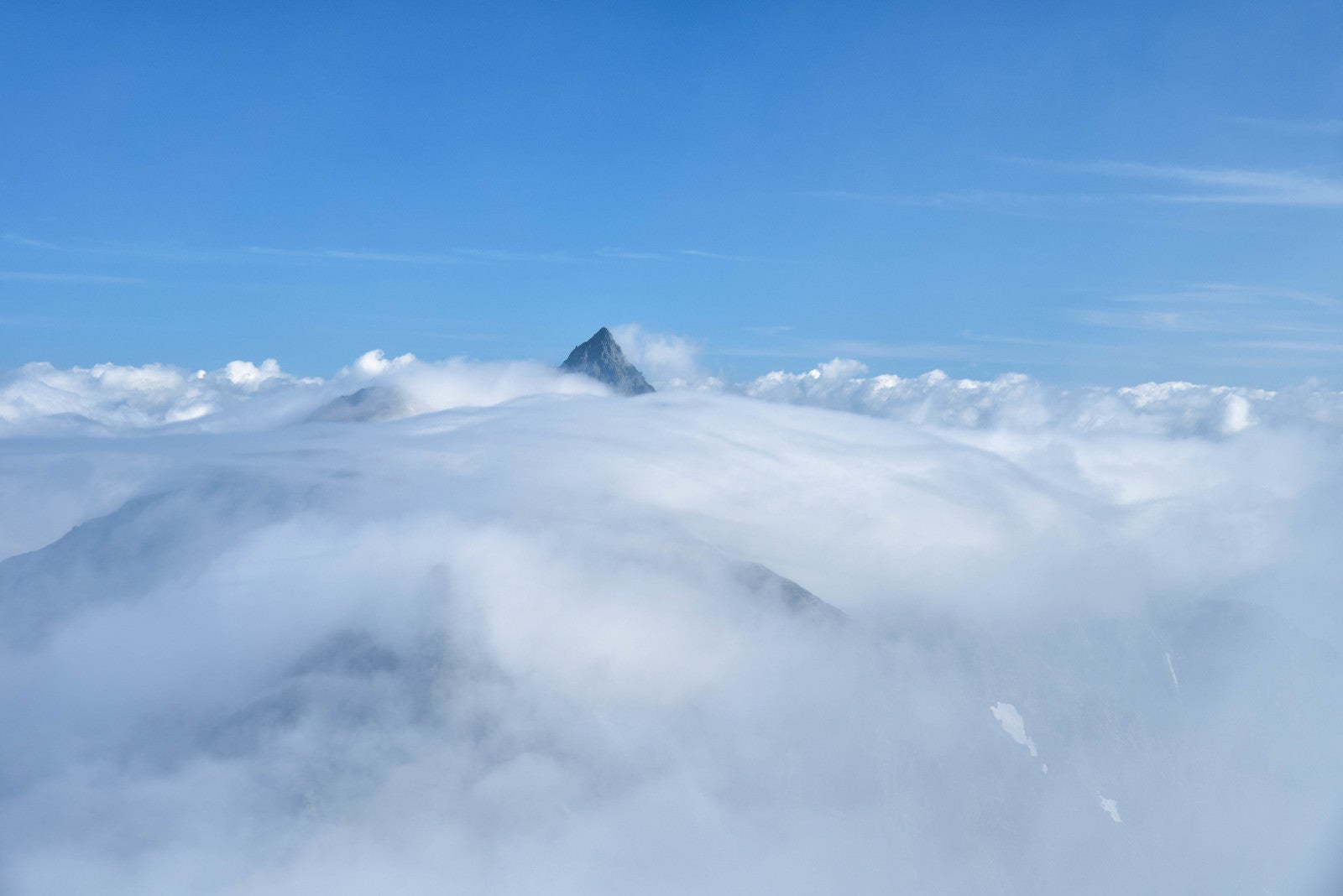 「雲から顔を出す槍ヶ岳（飛騨山脈）」の写真
