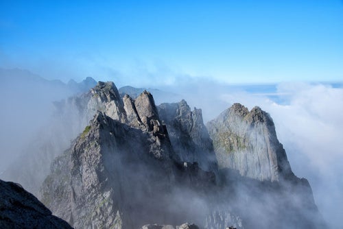 雲間から顔を出す滝谷の断崖（穂高連峰）の写真