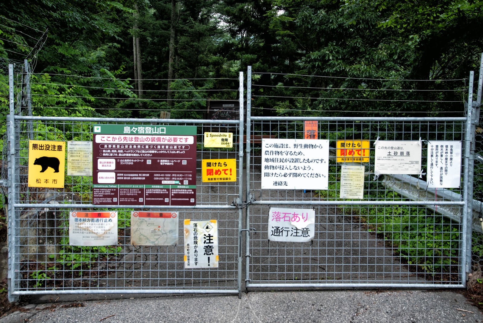 「徳本峠へ通じるゲートに取り付けられた警告の数々」の写真