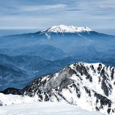 薄雲から頭を出す御嶽山と木曽前岳の写真