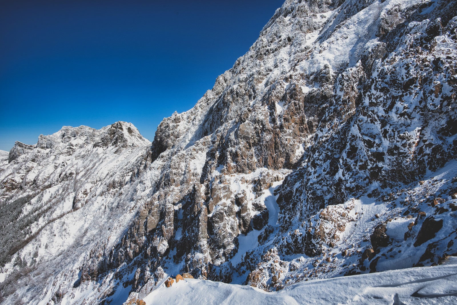 「雪が降った後の青空と赤岳の岩壁（八ヶ岳連峰）」の写真