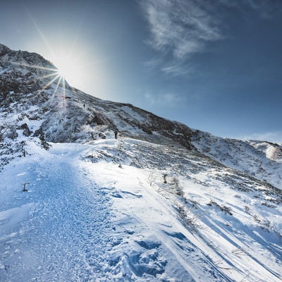 稜線に差し込む光と登山者の写真