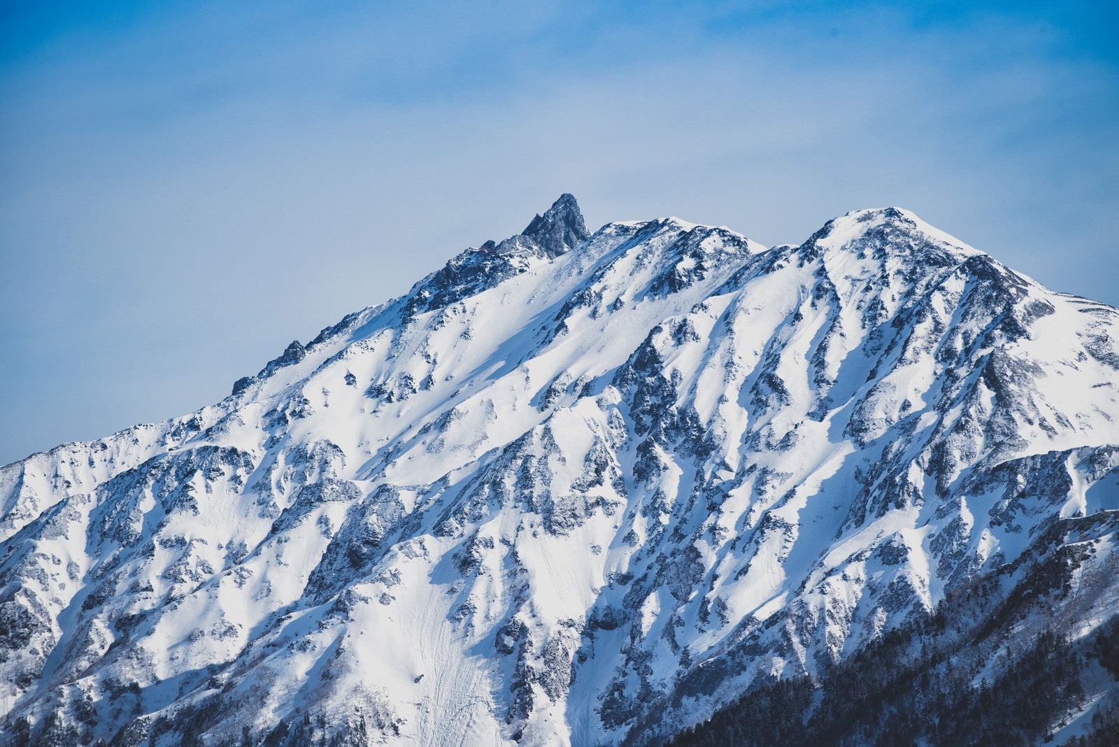 「雪化粧の山岳と黒い穂先」の写真