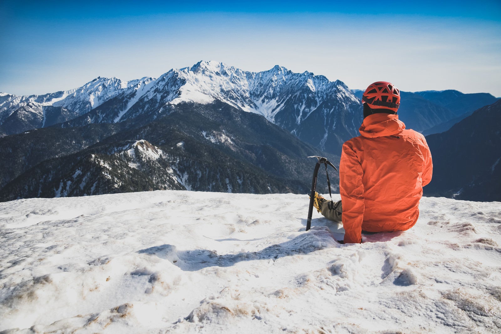 「穂高岳に思いを馳せる休憩中の登山者」の写真