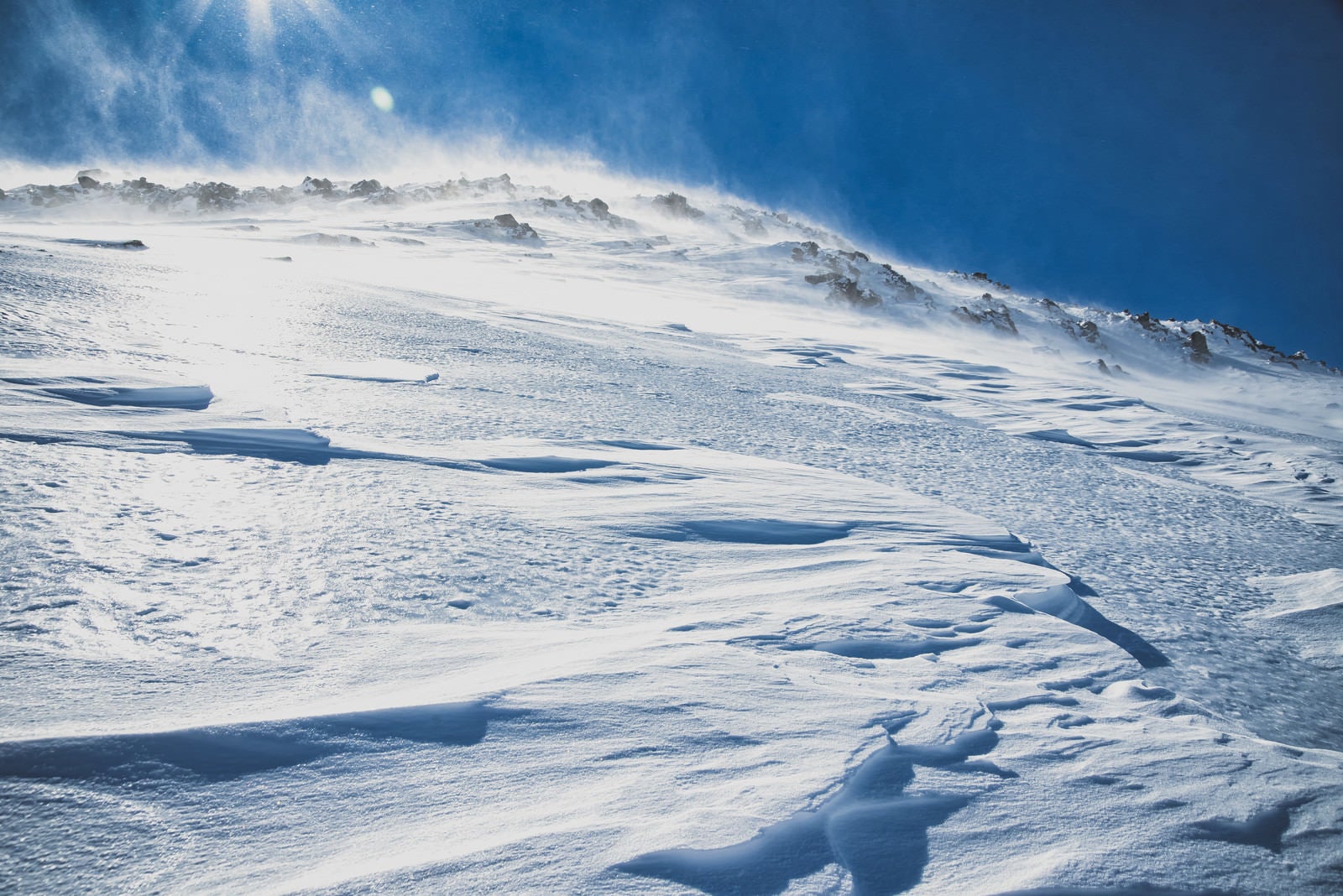 「強風に晒される雪山の斜面」の写真