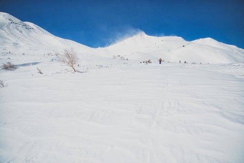 乗鞍高原を踏破するバックカントリースキーヤー（北アルプス）の写真