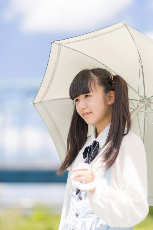 日傘をさすツインテールの女の子の写真