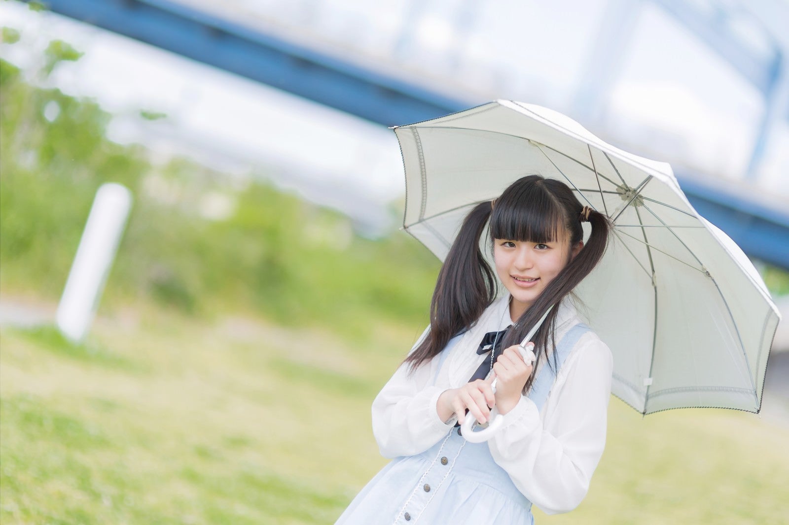 「日傘をさして笑顔で微笑むツインテールの女の子」の写真［モデル：こころ］