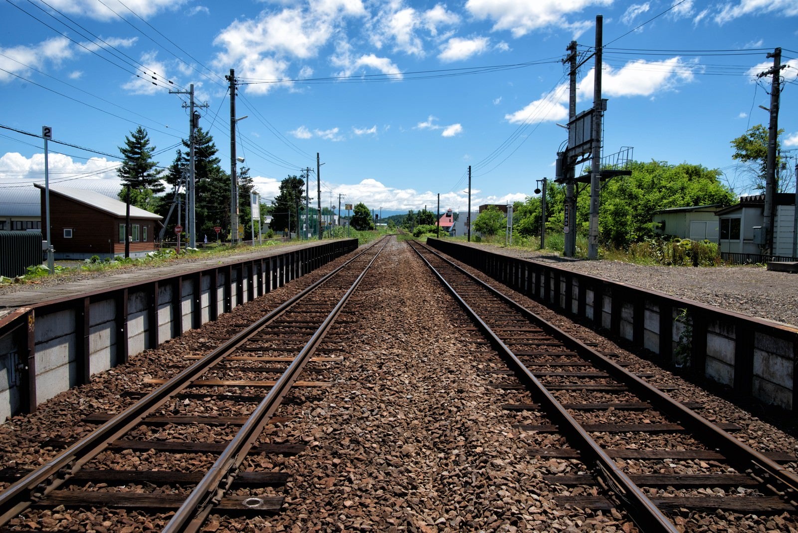 「JR富良野線のホームと千代ヶ岡駅舎から続く線路」の写真