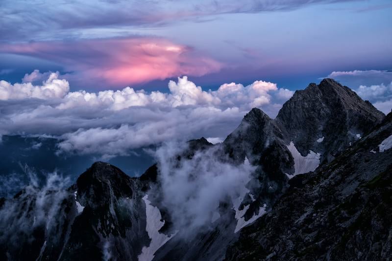 赤く染まる積雲と前穂高岳の写真